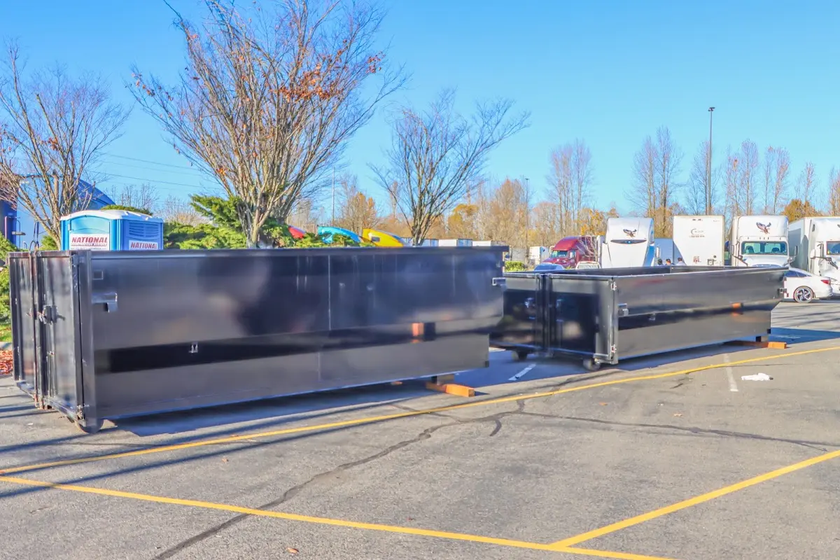 Professional dumpster rental service with roll-off container on residential driveway in Presque Isle
